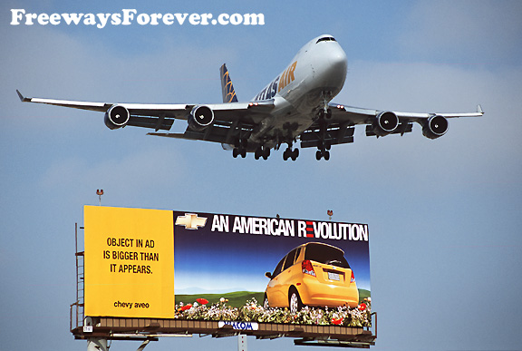 747 Jet flying above billboard for Chevy Aveo