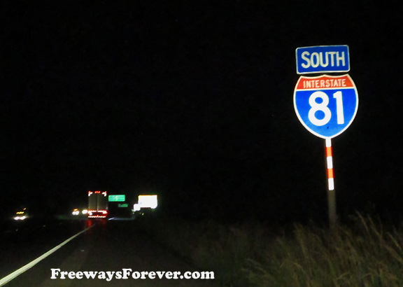 Night photo of Interstate 81 sign with striped pole