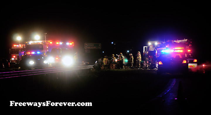 Emergency personnel working on Interstate wreck site at night
