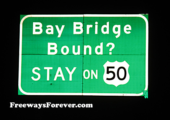 Bay Bridge Bound Stay on U.S. Route 50 highway sign at night